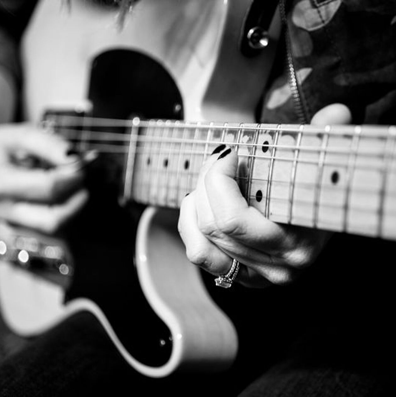 black and white photo of a person playing an electric guitar