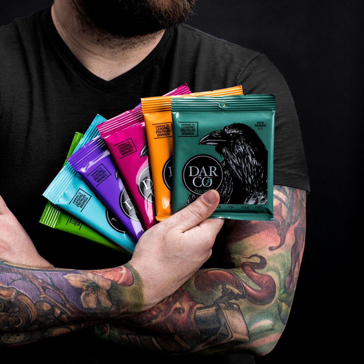 Person holding colorful packs of guitar strings
