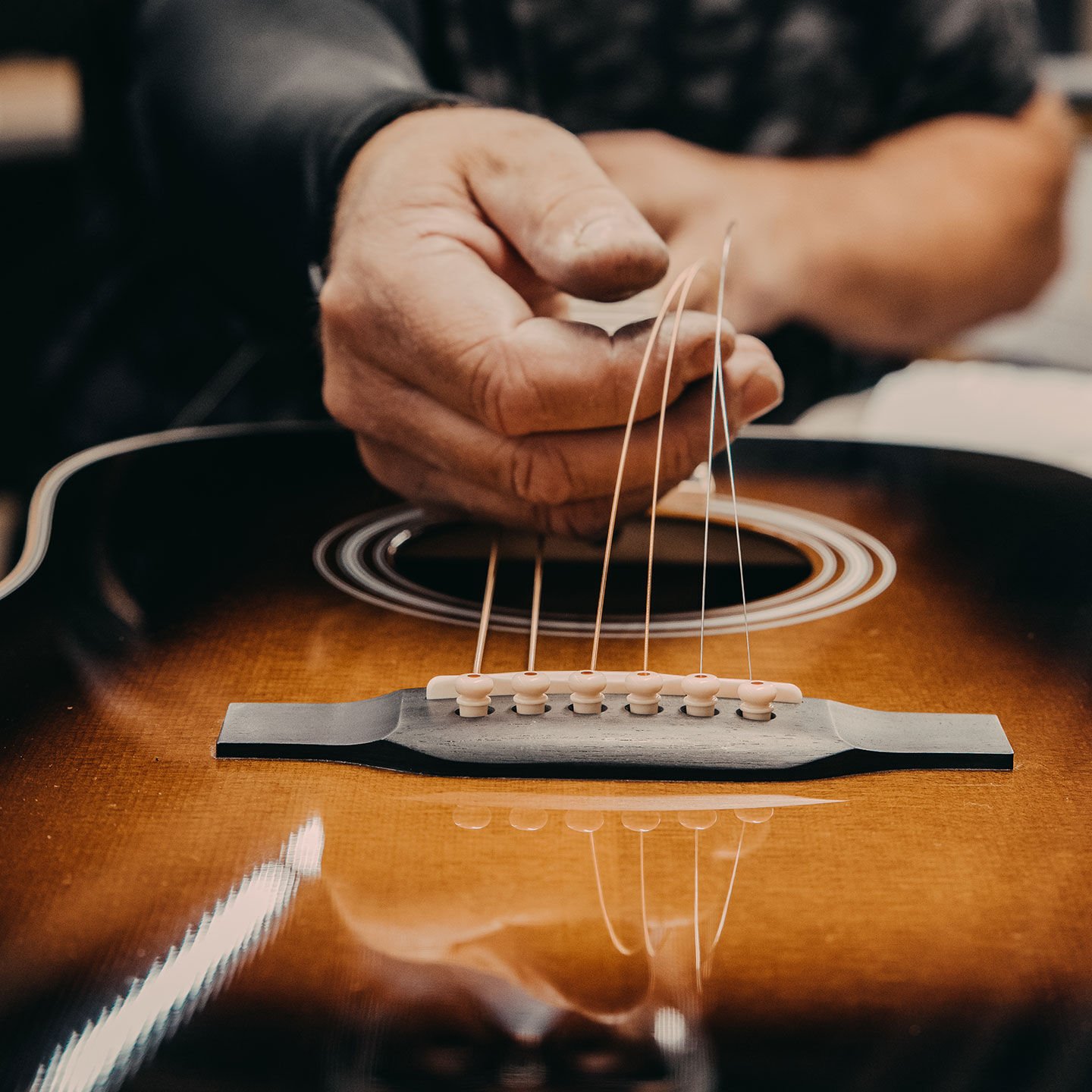 Close up of hands stringing a guitar