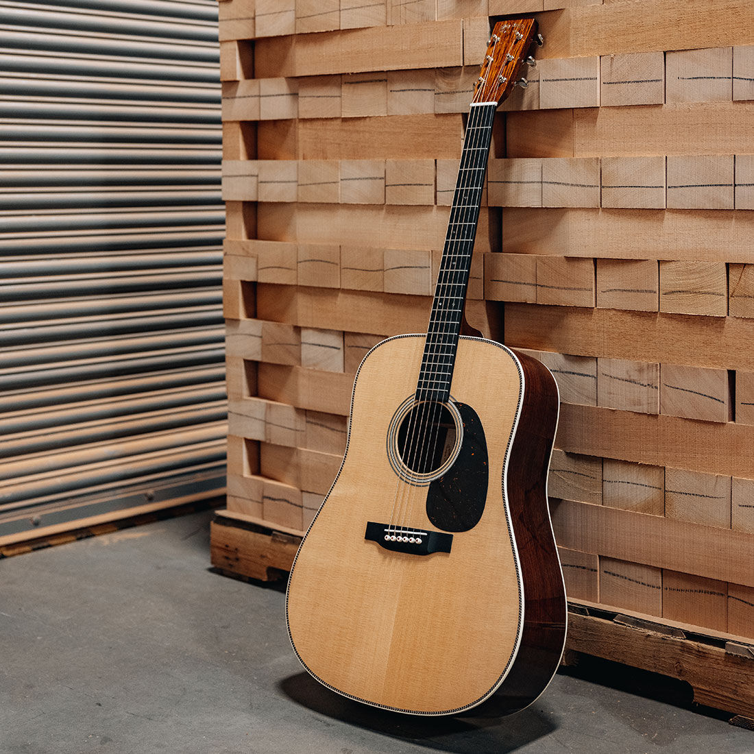 Acoustic guitar standing against a wooden wall