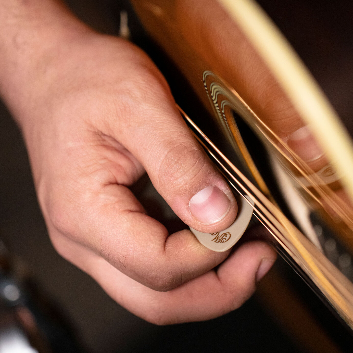 Strumming a guitar with a pick