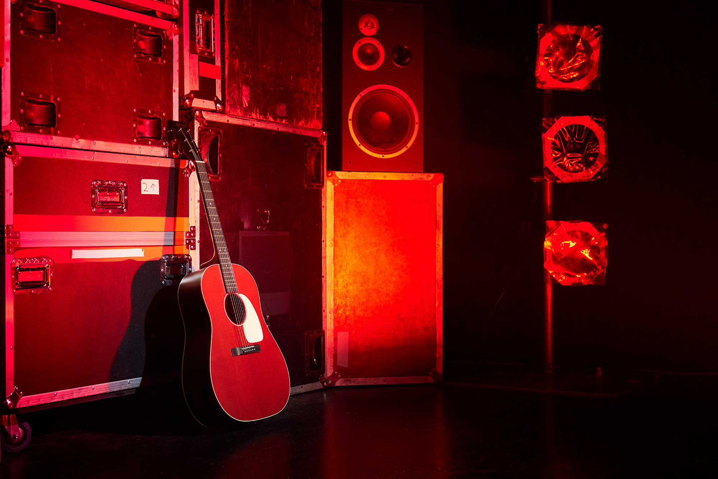 The Cherry Cola DSS leaning against an amplifier in a room with red lights