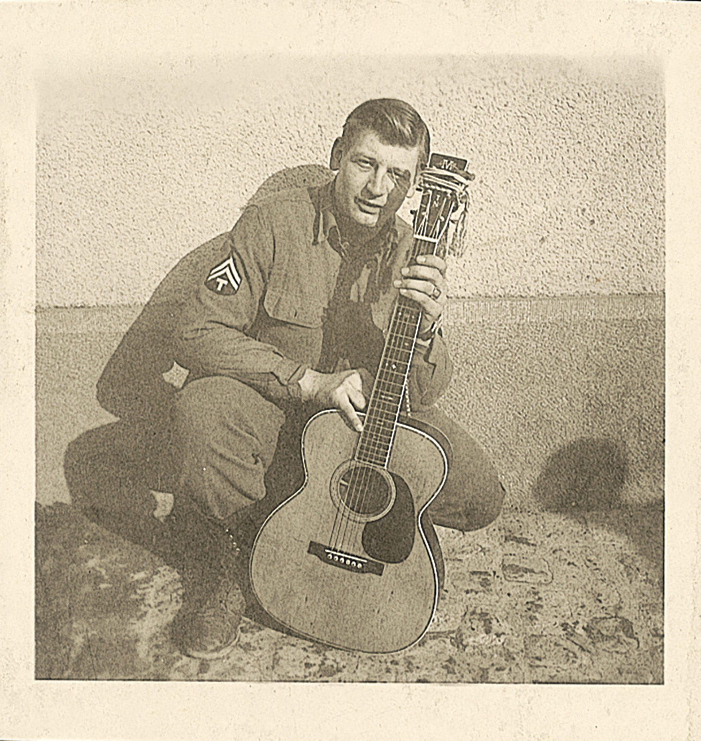 John with his guitar during the war