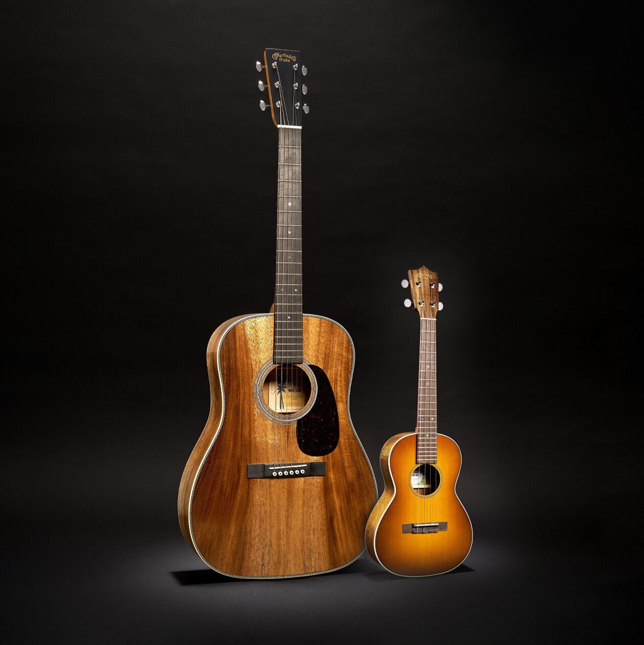 An all-Koa acoustic guitar against a black background