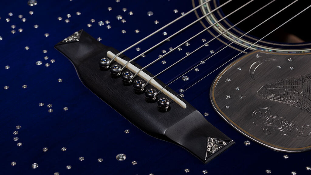 Closeup of a dark blue acoustic guitar with silver stars on it