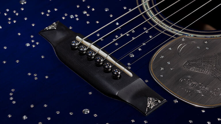 Closeup of a dark blue acoustic guitar with silver stars on it