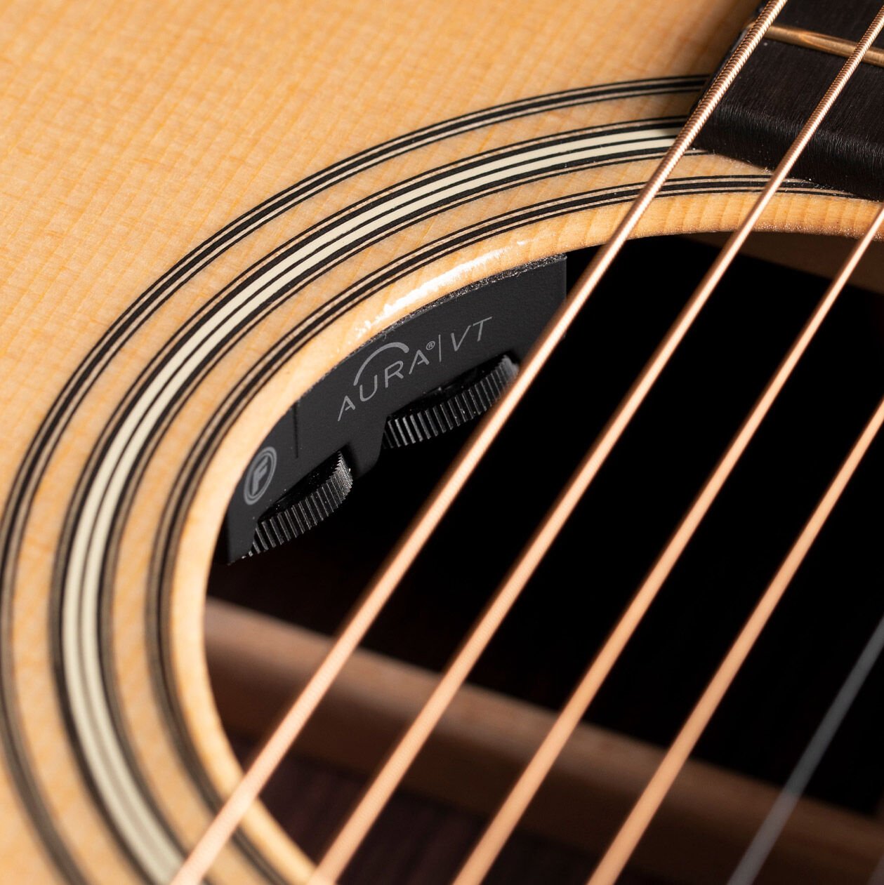 Close up of a pickup inside an acoustic guitar sound hole