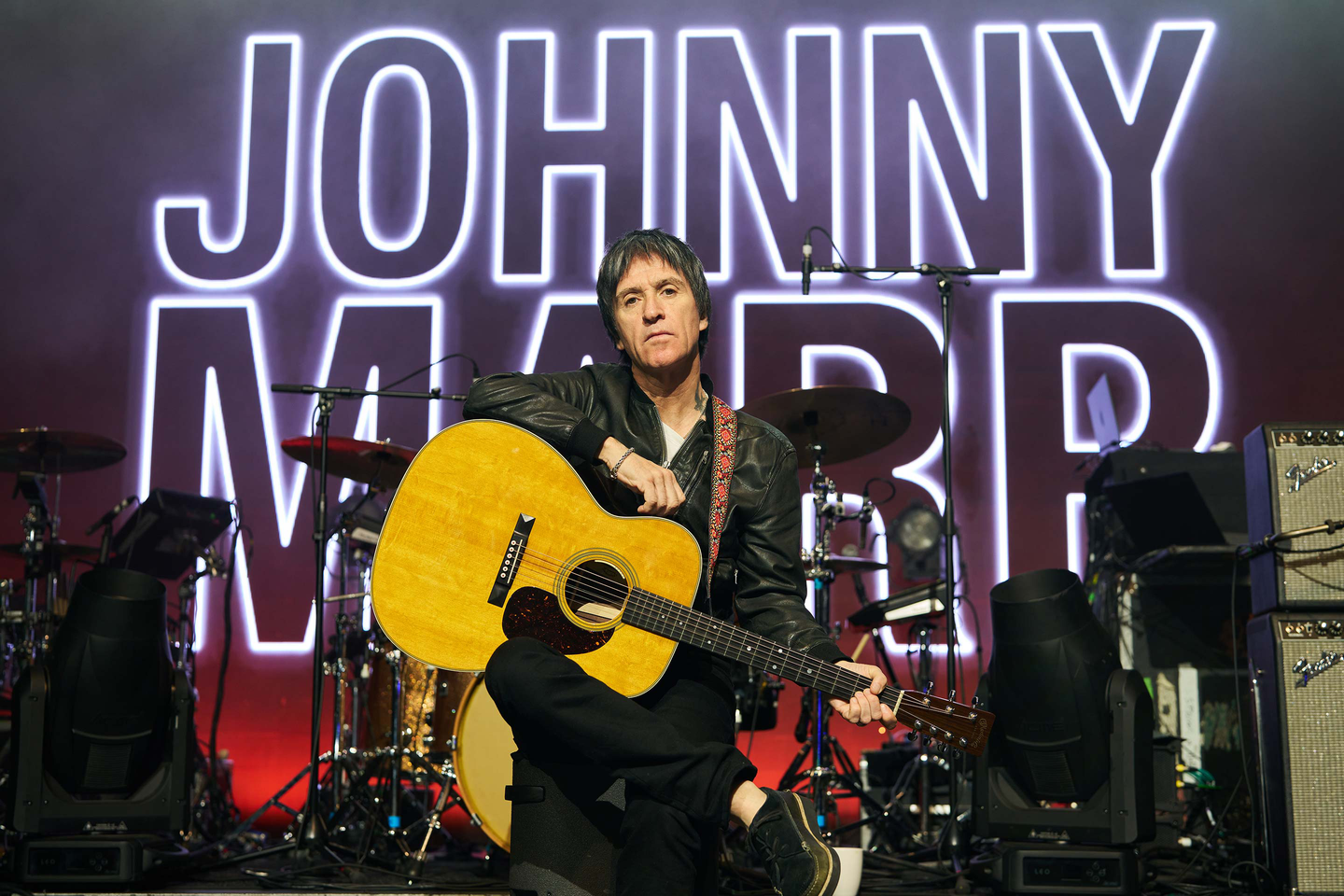 Johnny Marr posing with his guitar on stage