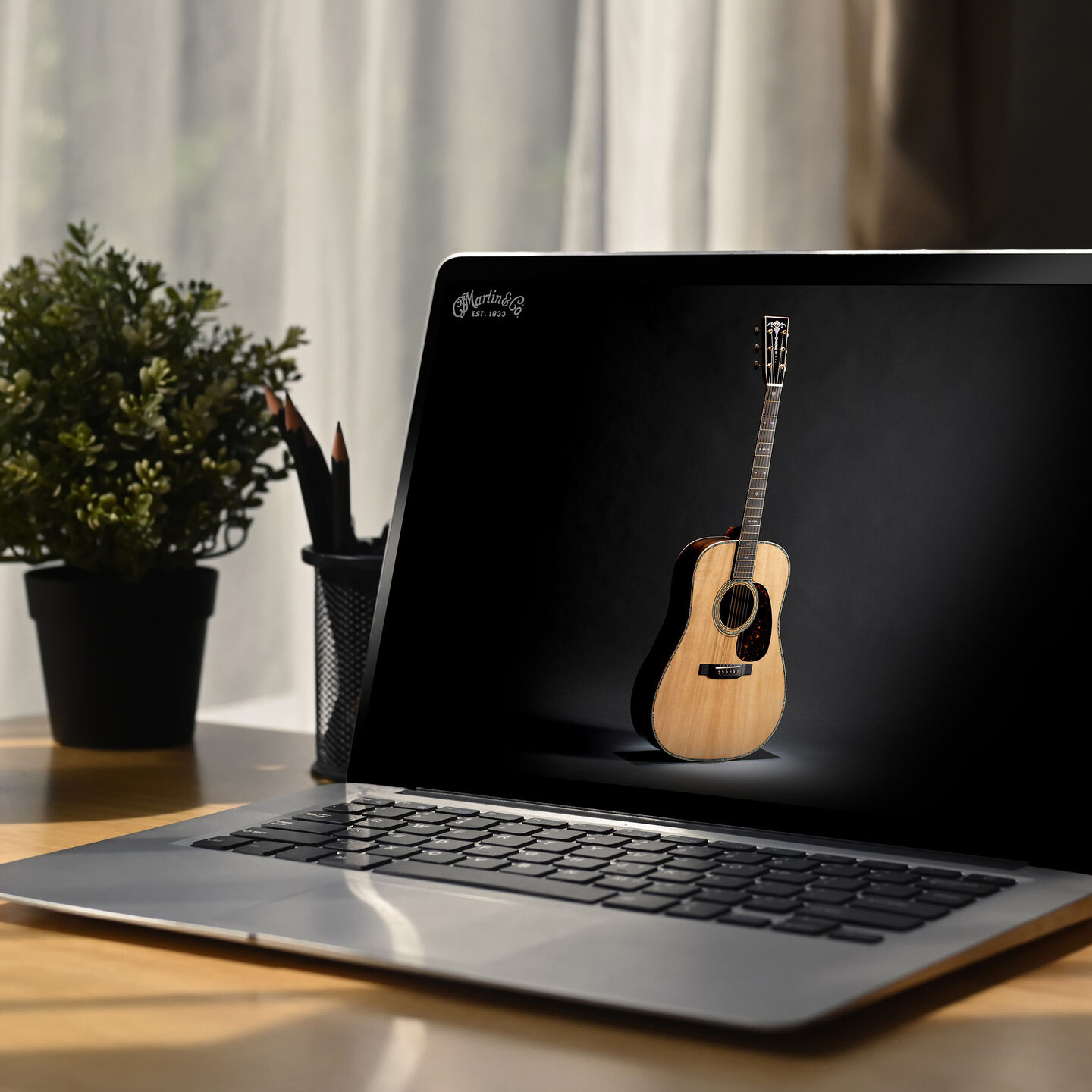 Photo of an acoustic guitar on an open laptop screen
