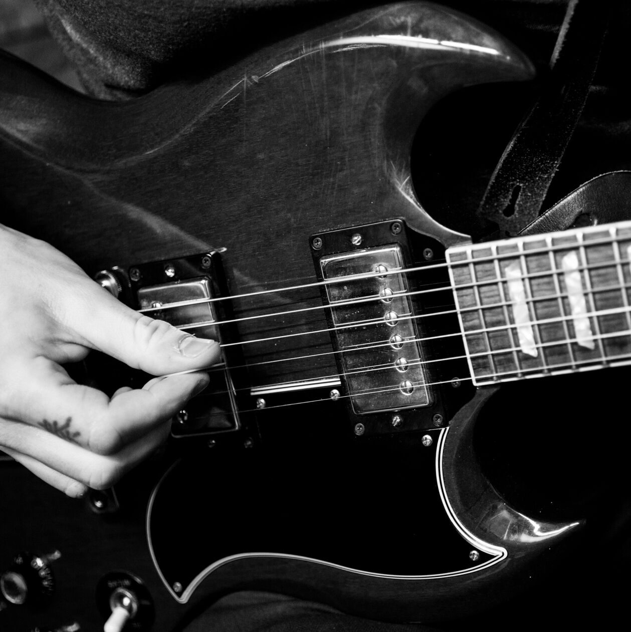 Black and white photo of a person playing an electric guitar