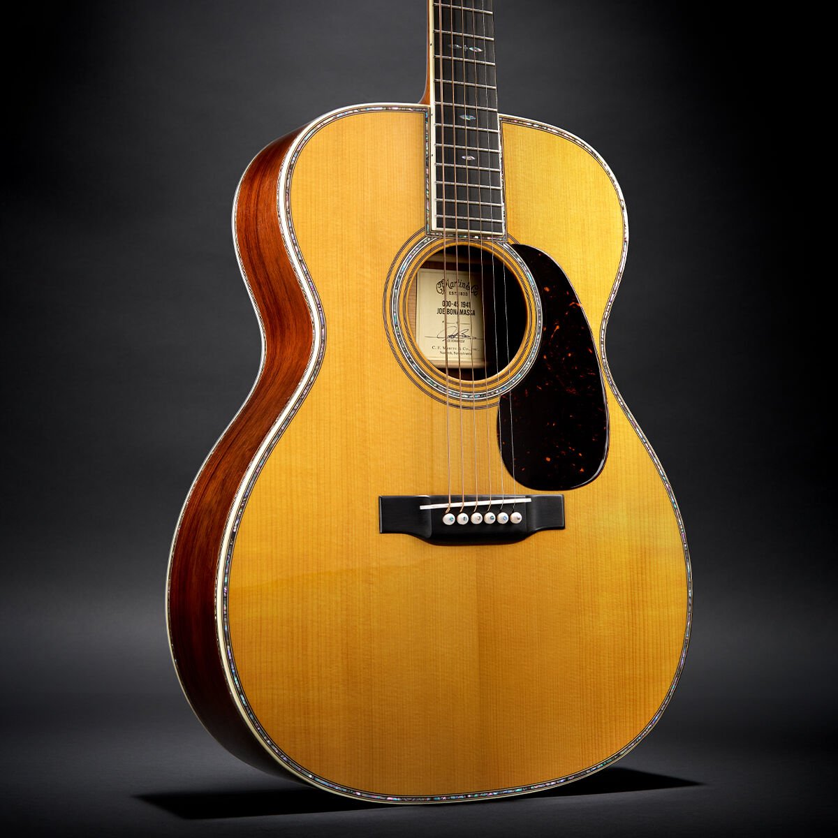Closeup of acoustic guitar body on black background