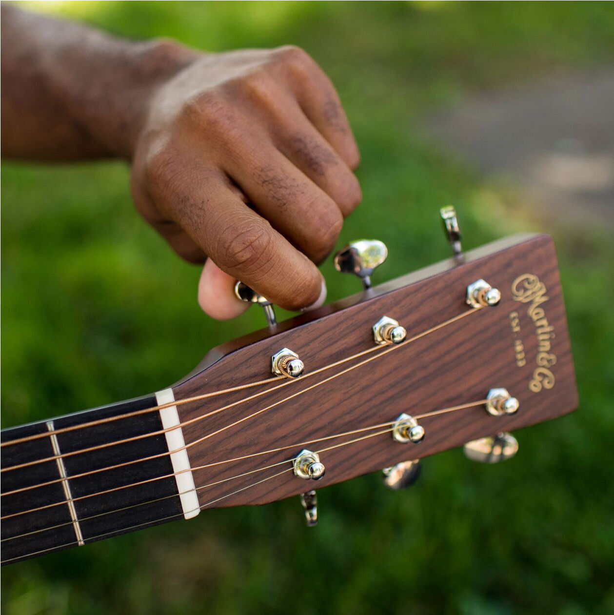 A person tuning an acoustic guitar A person tuning an acoustic guitar
