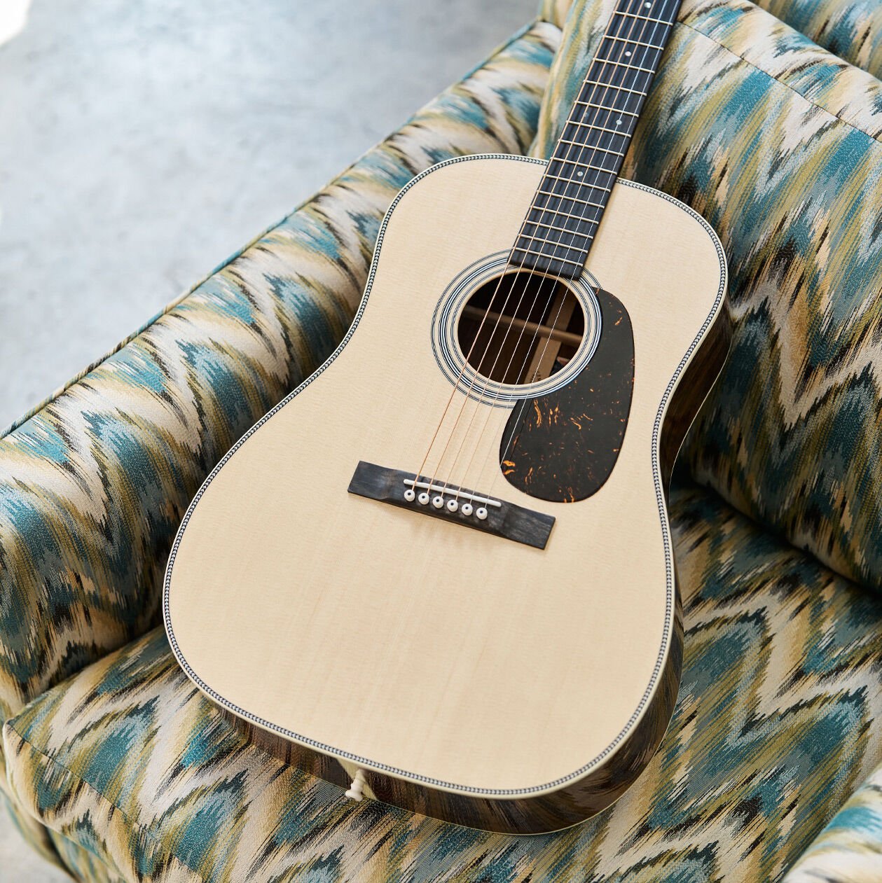 An acoustic guitar on a sofa