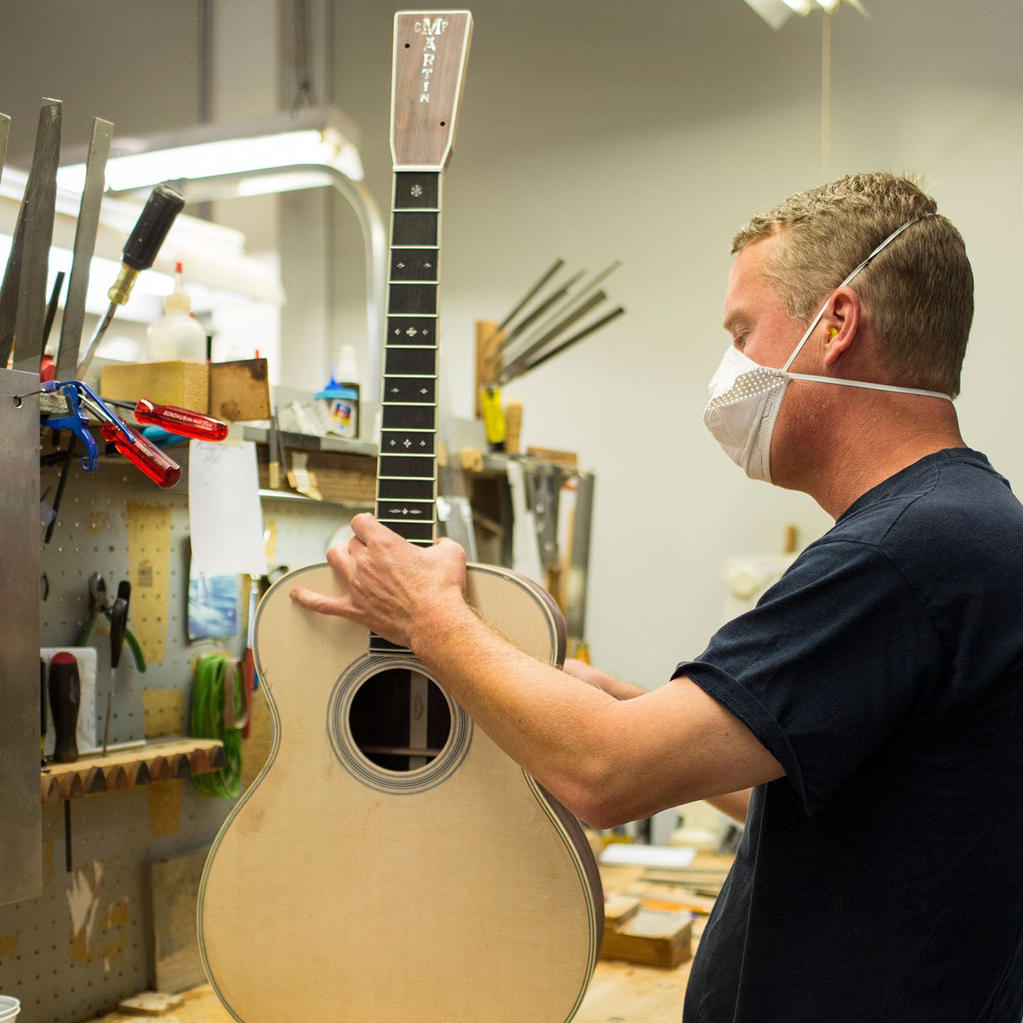 Factory worker building a guitar