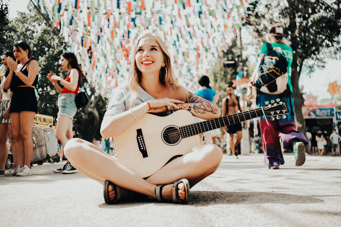 Young woman sitting cross-legged holding a Little Martin