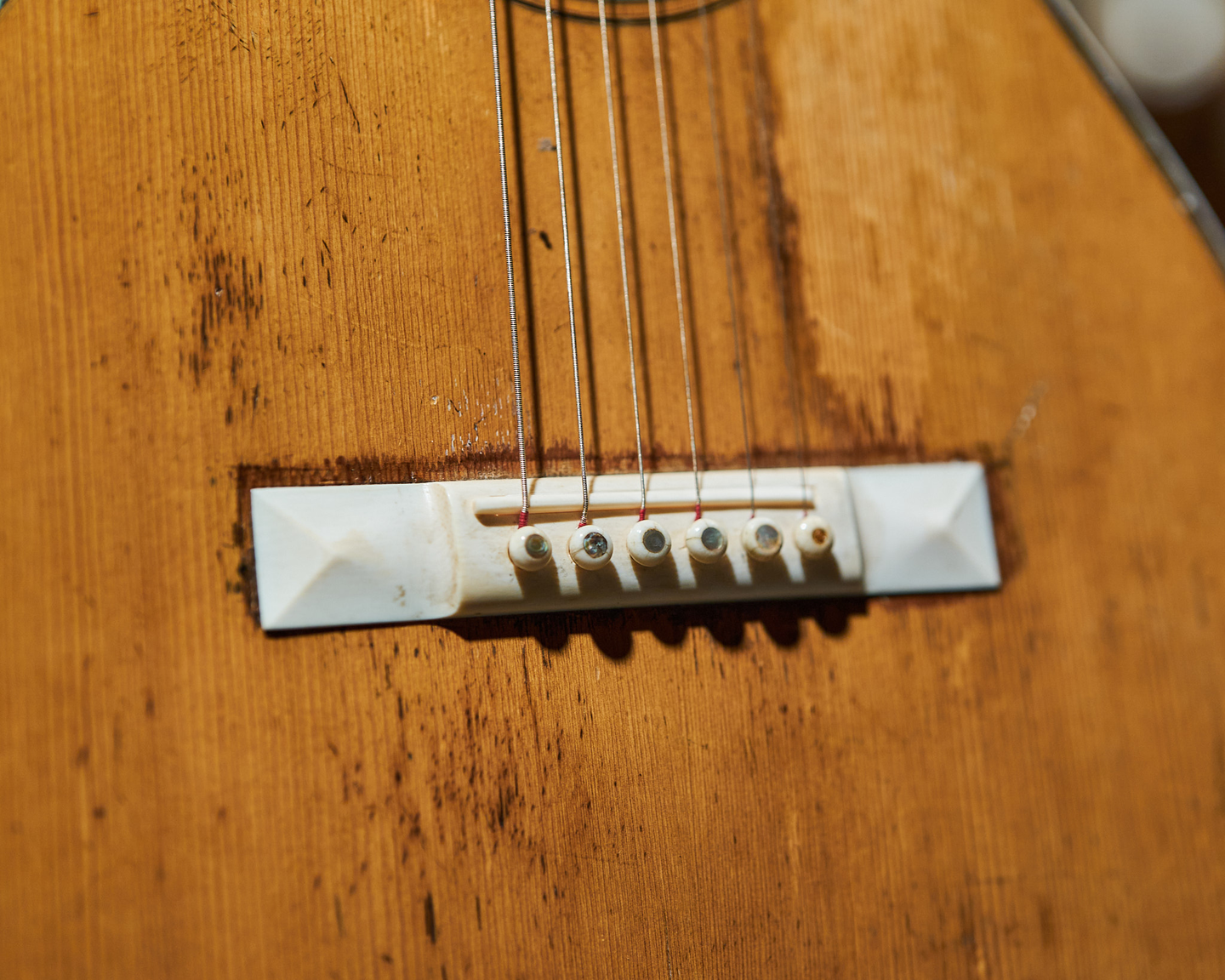 Photo of the bridge on an acoustic guitar