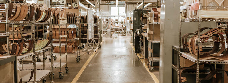 The hallway of a guitar factory with wooden guitar bodies on either side