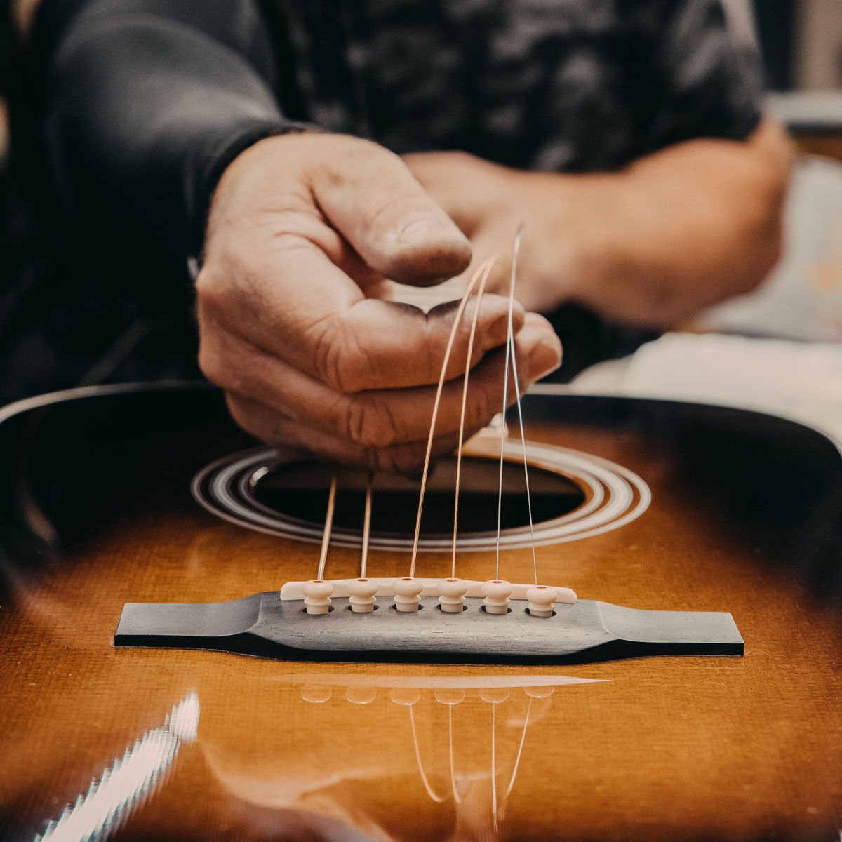 A person stringing the guitar
