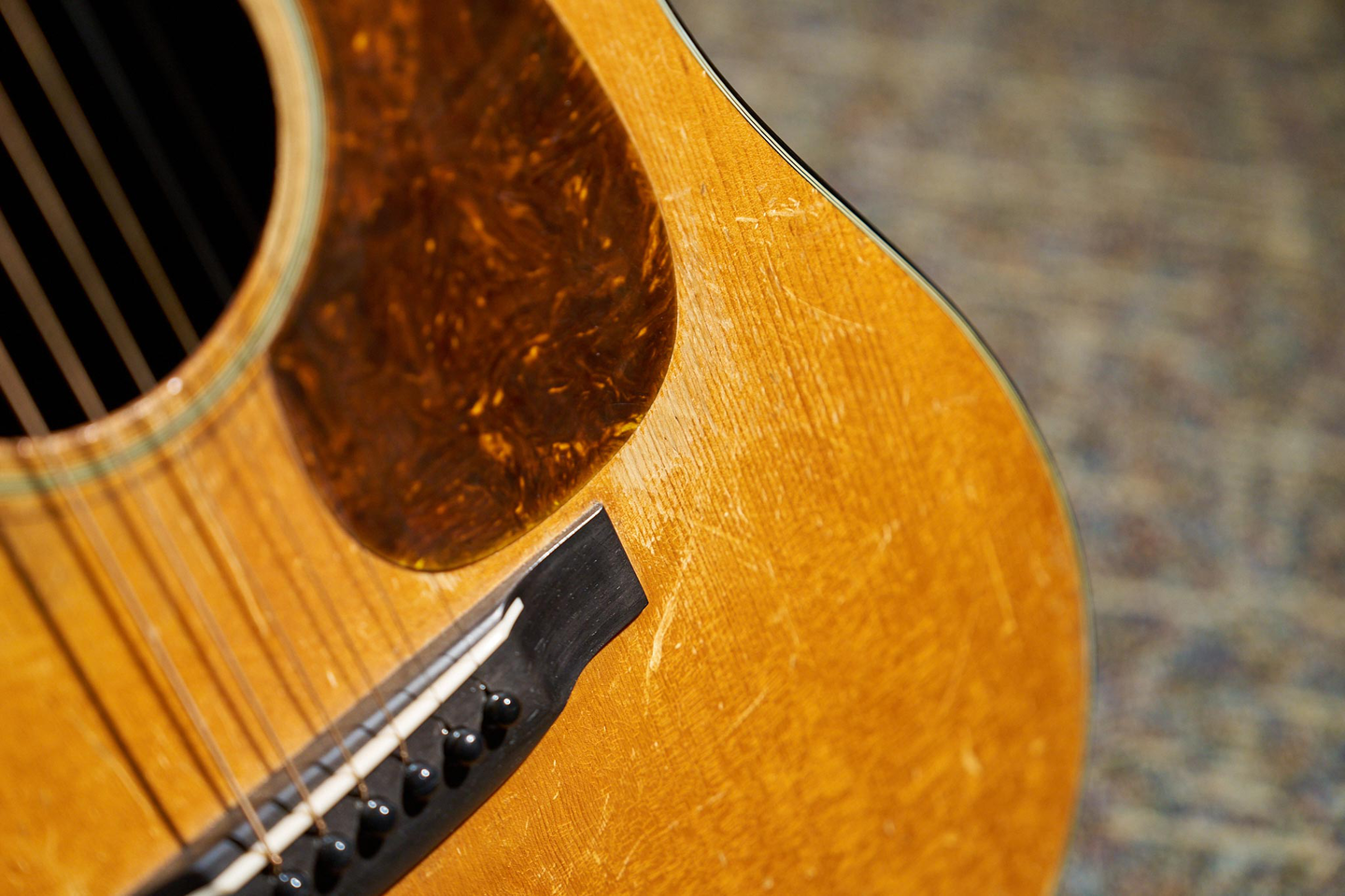 A photo of James Taylor's 1937 D-18, showing the bridge, pickguard, and lower area of the front A photo of James Taylor's 1937 D-18, showing the bridge, pickguard, and lower area of the front