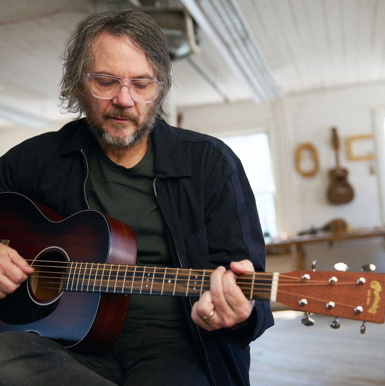 Jeff Tweedy playing his signature acoustic guitar Jeff Tweedy playing his signature acoustic guitar