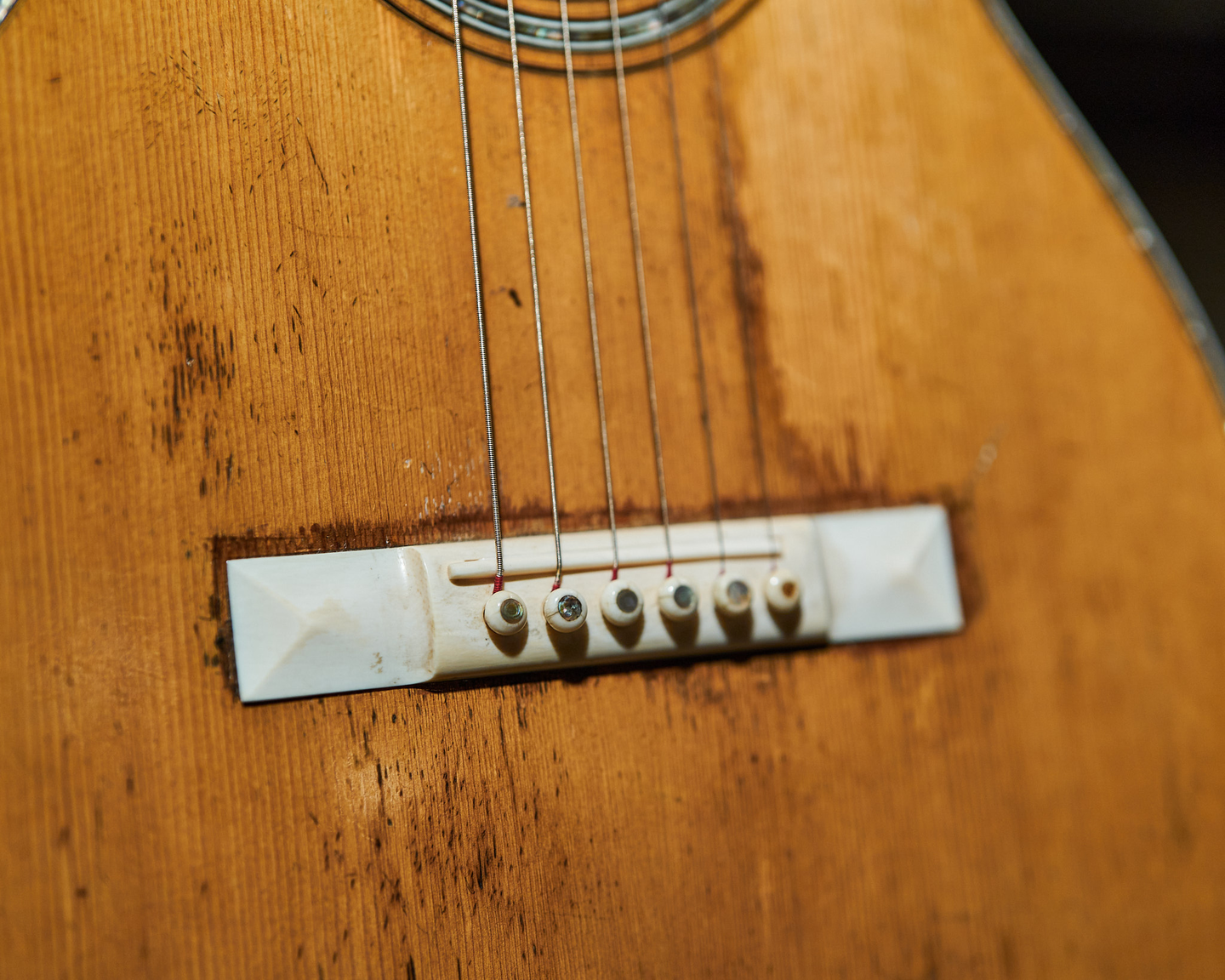 Photo of the bridge on an acoustic guitar