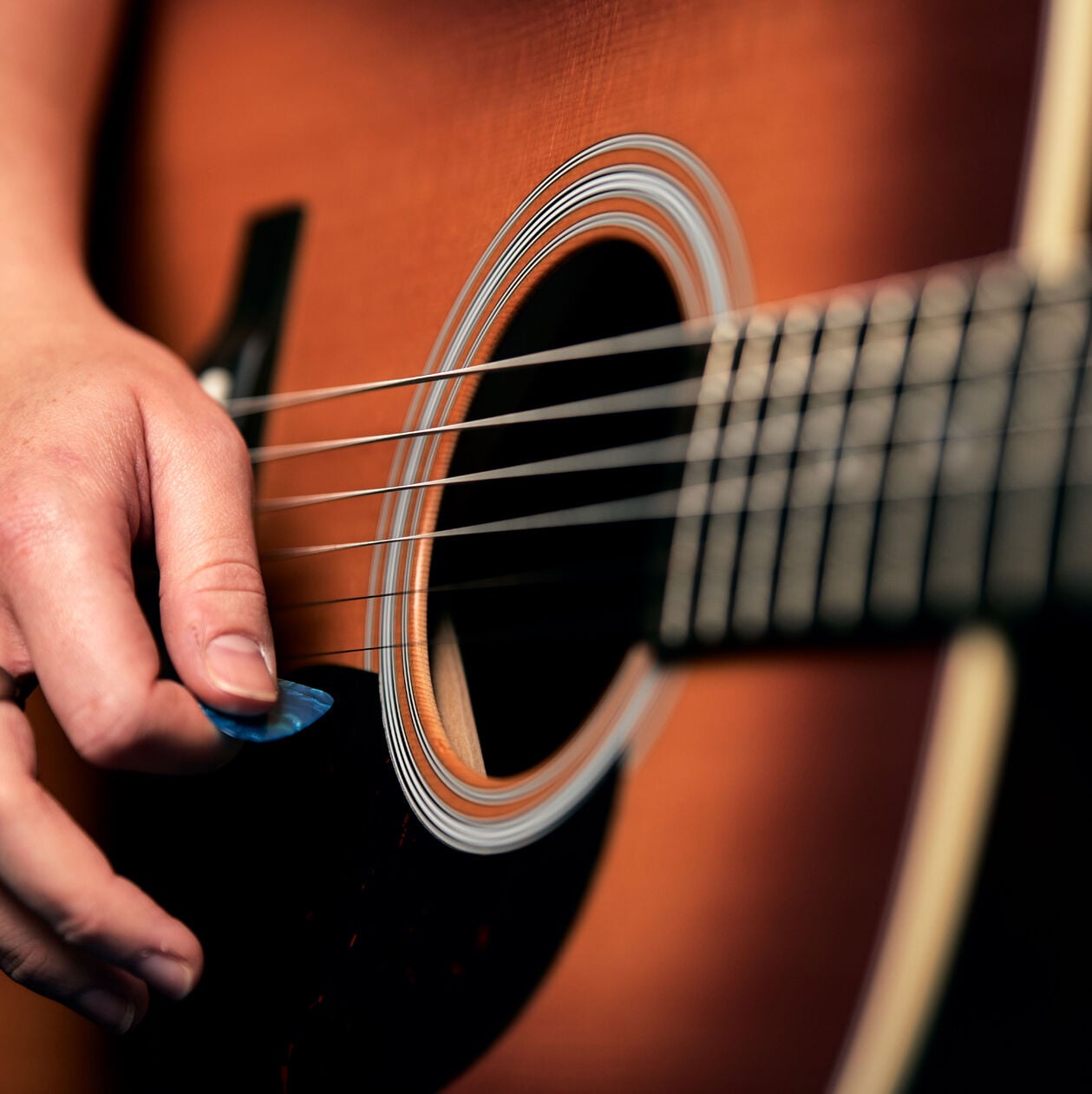 Closeup of an acoustic guitar sound hole and strings