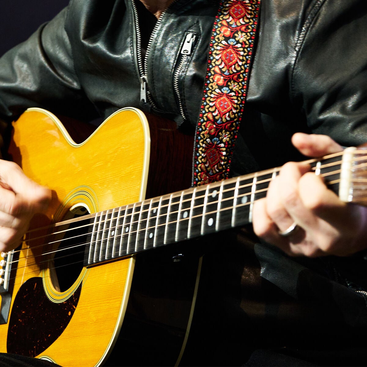 Closeup of hands playing an acoustic guitar