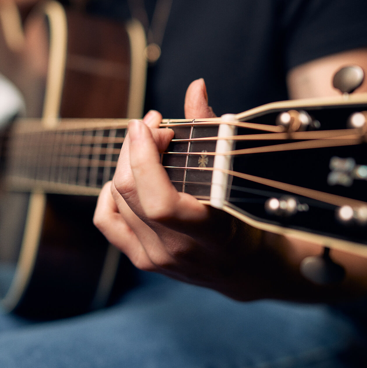Person playing a chord on a guitar